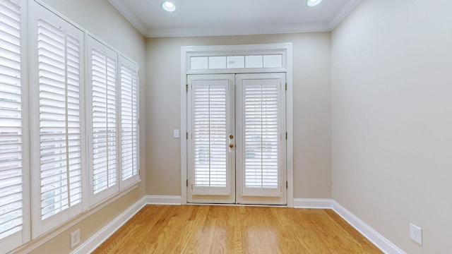 entryway with ornamental molding and light hardwood / wood-style floors