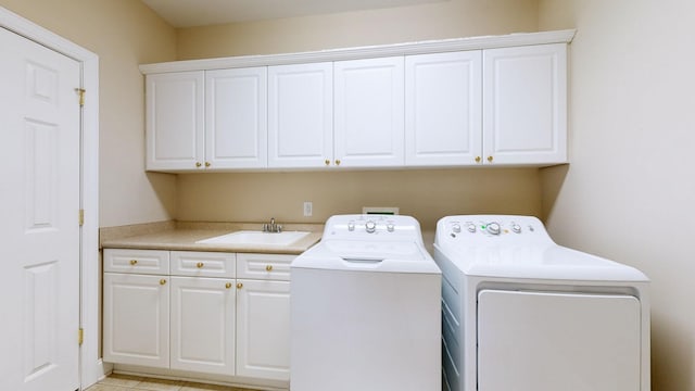 laundry area with sink, washing machine and dryer, and cabinets