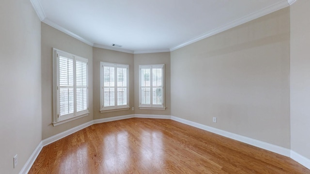 spare room featuring hardwood / wood-style flooring and ornamental molding