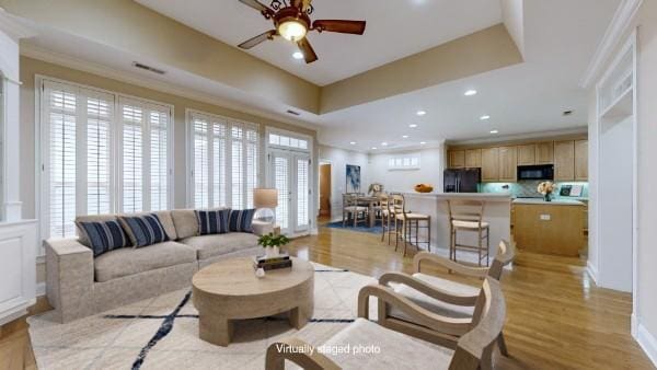 living room featuring crown molding, french doors, light hardwood / wood-style flooring, and a wealth of natural light