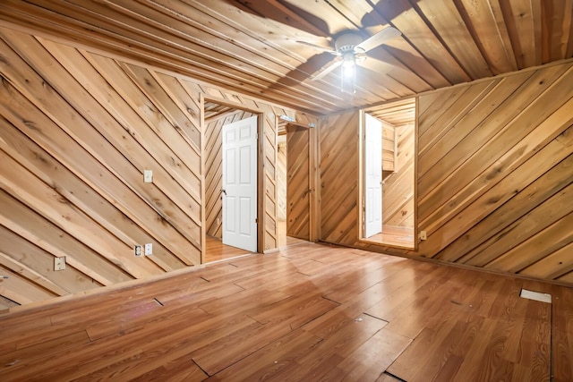 additional living space featuring ceiling fan, wooden ceiling, and wood walls