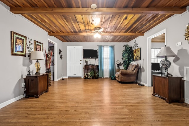 sitting room with ceiling fan, beam ceiling, and light wood-type flooring