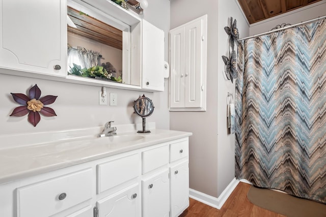 bathroom featuring wooden ceiling, hardwood / wood-style floors, walk in shower, and vanity