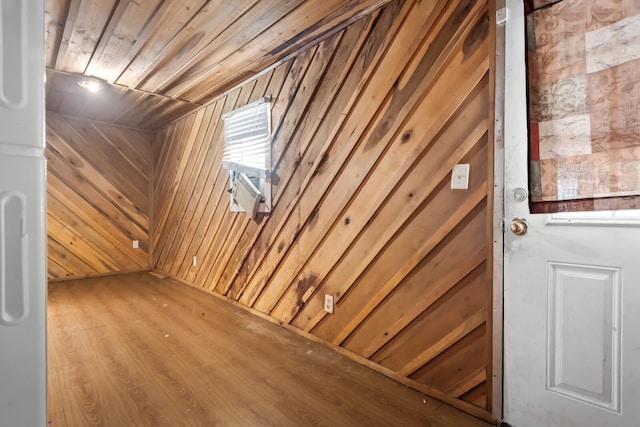 interior space featuring light wood-type flooring, wooden walls, and wooden ceiling