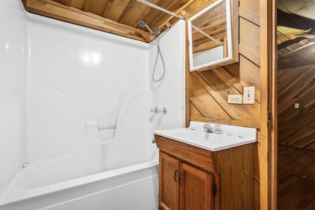 bathroom with wooden ceiling, wood walls, and vanity