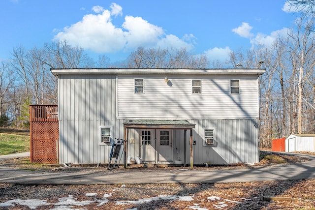 rear view of property featuring a shed