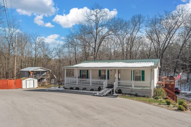 view of front of house featuring a porch and a shed