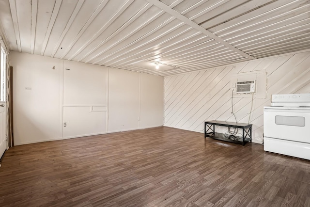 basement featuring a wall mounted AC and dark hardwood / wood-style flooring