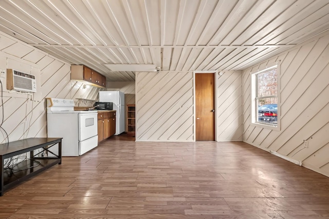 kitchen featuring white appliances, dark hardwood / wood-style flooring, wooden walls, and a wall mounted air conditioner