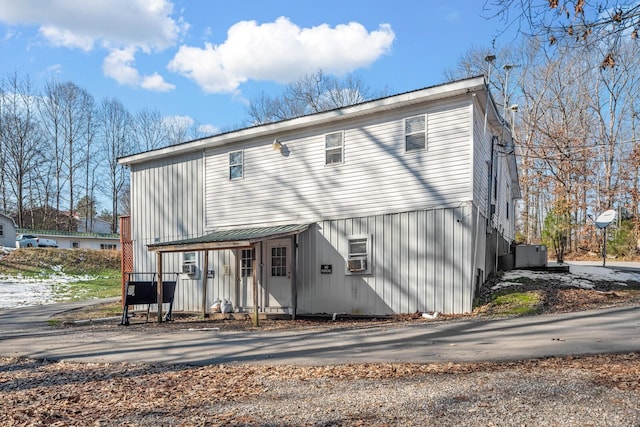 rear view of property featuring cooling unit and a porch