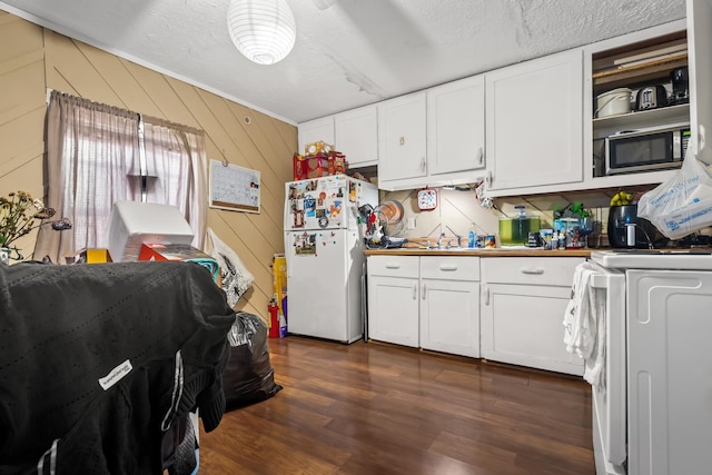 kitchen featuring white cabinets, white refrigerator, dark hardwood / wood-style flooring, and wooden walls