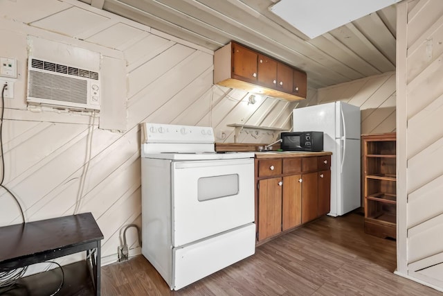 kitchen featuring dark wood-type flooring, a wall unit AC, white appliances, and wood walls