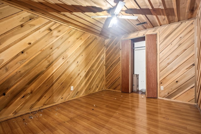 empty room featuring wood walls, wooden ceiling, and wood-type flooring