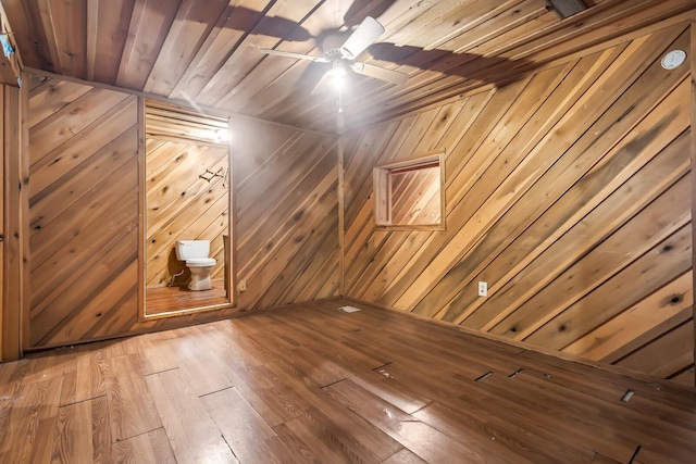 bonus room featuring ceiling fan, wooden ceiling, and wooden walls