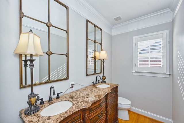 bathroom with toilet, vanity, wood-type flooring, and ornamental molding