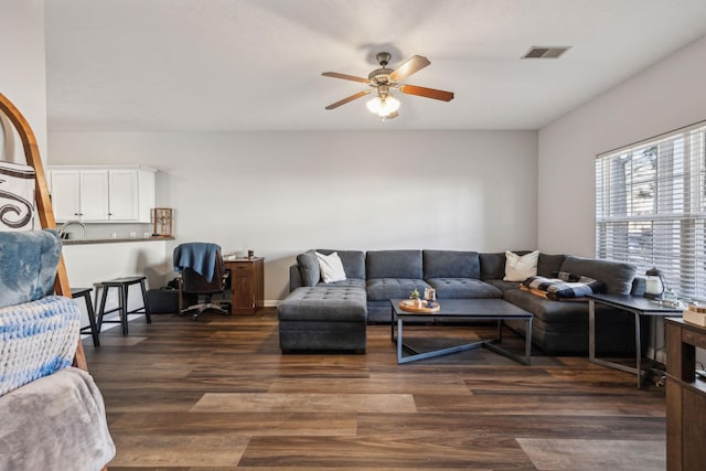 living room featuring ceiling fan and dark hardwood / wood-style flooring