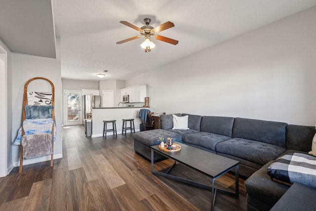 living room featuring ceiling fan and dark hardwood / wood-style floors