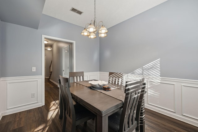 dining room with lofted ceiling, dark hardwood / wood-style floors, and an inviting chandelier