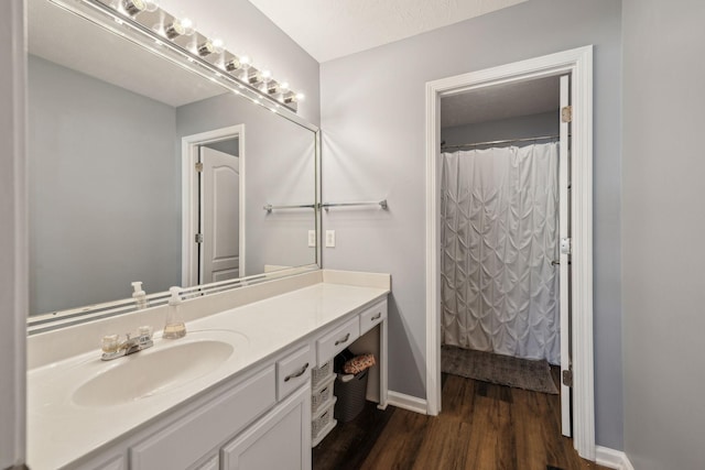 bathroom with vanity, a shower with curtain, a textured ceiling, and hardwood / wood-style flooring