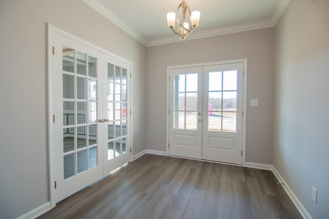 entryway featuring hardwood / wood-style floors, ornamental molding, french doors, and a chandelier