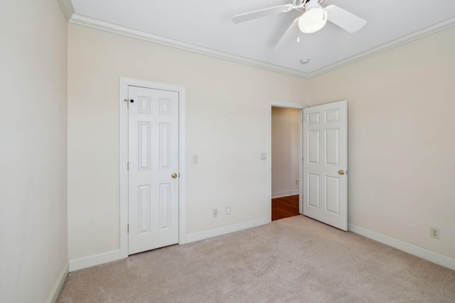 unfurnished bedroom with ceiling fan, crown molding, and light colored carpet