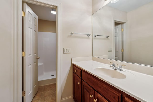 bathroom with tile patterned floors, walk in shower, and vanity