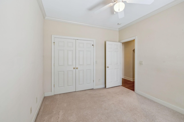 unfurnished bedroom with ceiling fan, light carpet, a closet, and ornamental molding