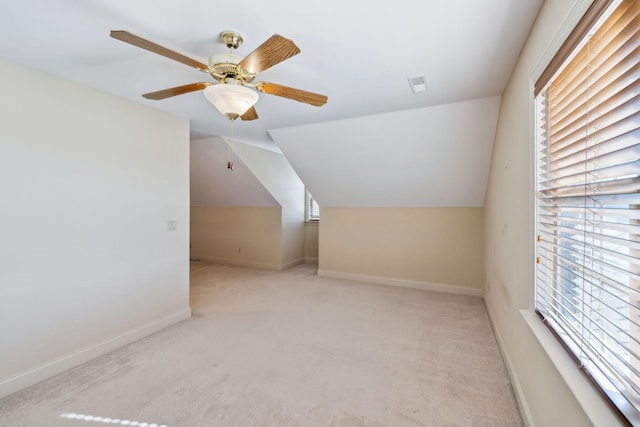 bonus room featuring ceiling fan, light colored carpet, vaulted ceiling, and a healthy amount of sunlight