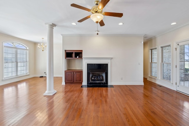 unfurnished living room with ceiling fan, crown molding, hardwood / wood-style floors, and decorative columns