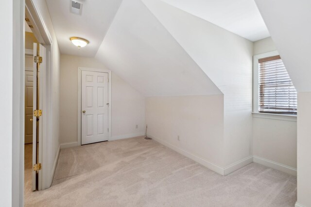 bonus room featuring light colored carpet and vaulted ceiling