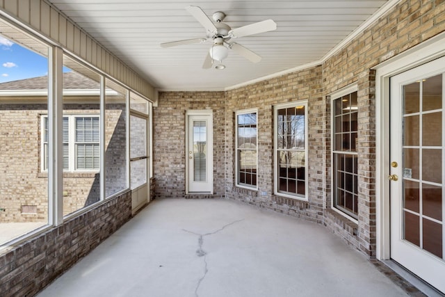 unfurnished sunroom featuring ceiling fan