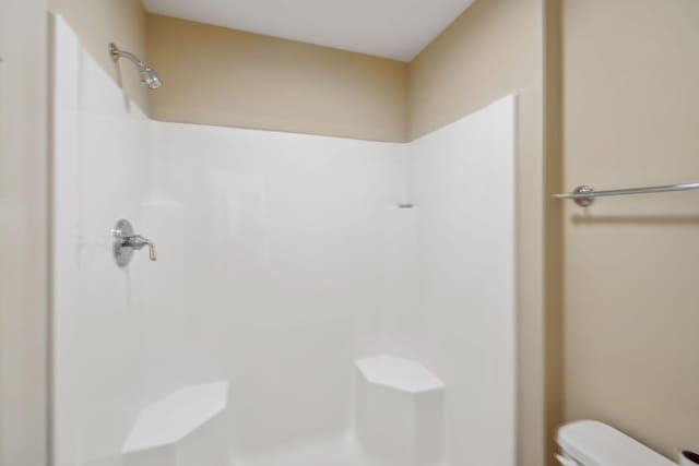 bathroom with toilet and walk in shower