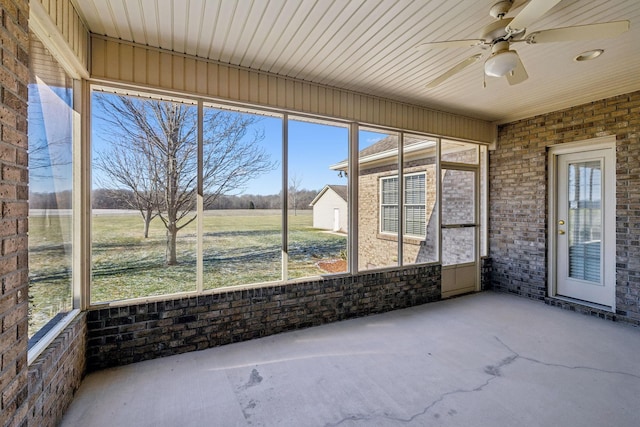 unfurnished sunroom with ceiling fan