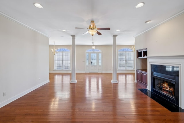 living room featuring ceiling fan with notable chandelier, crown molding, dark hardwood / wood-style floors, and ornate columns