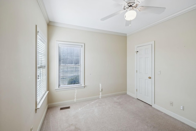 empty room with ceiling fan, ornamental molding, and light carpet