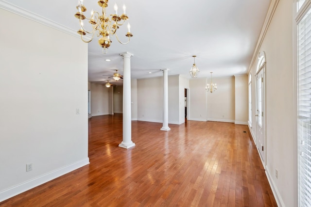 unfurnished living room featuring ceiling fan with notable chandelier, crown molding, ornate columns, and hardwood / wood-style floors