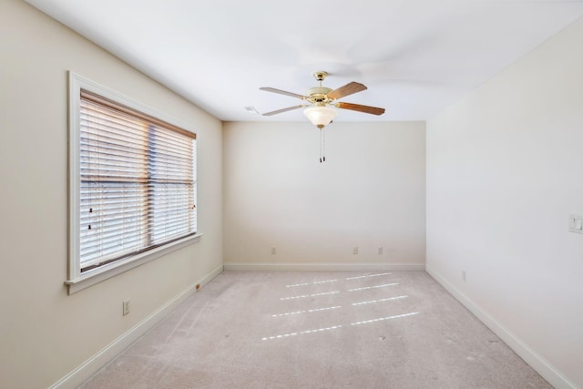 empty room featuring ceiling fan and light colored carpet