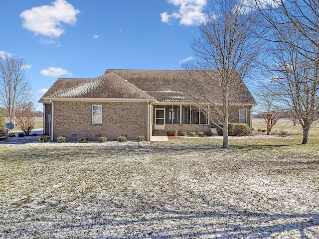 view of side of home with a sunroom and a yard