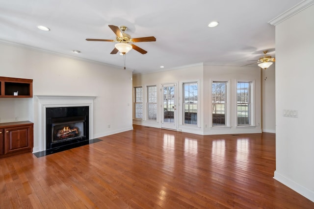 unfurnished living room with hardwood / wood-style flooring, ornamental molding, and ceiling fan