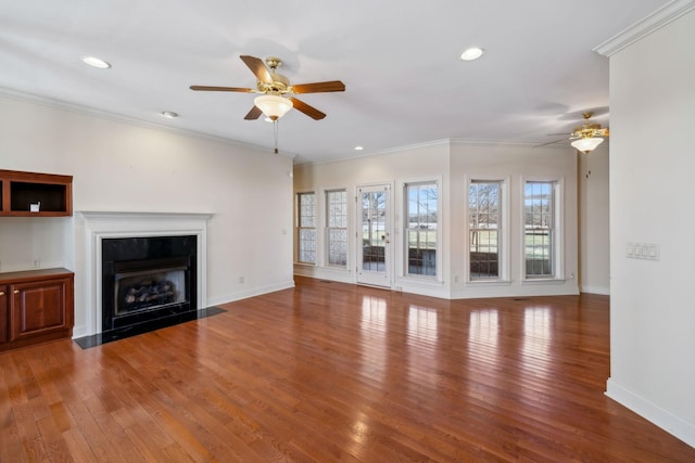 unfurnished living room featuring hardwood / wood-style flooring, ornamental molding, and ceiling fan