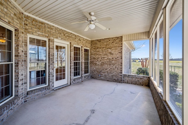 unfurnished sunroom with ceiling fan