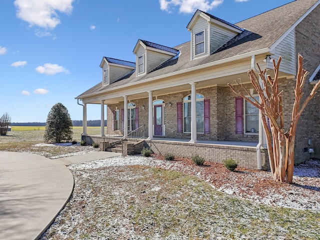 cape cod home featuring a porch