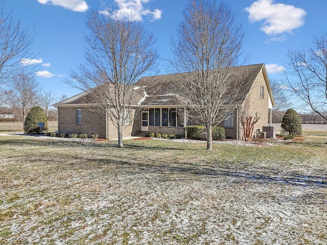 view of front of home featuring a front lawn, a sunroom, and cooling unit