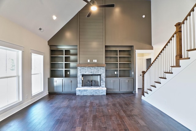 unfurnished living room with high vaulted ceiling, dark hardwood / wood-style floors, ceiling fan, and a fireplace