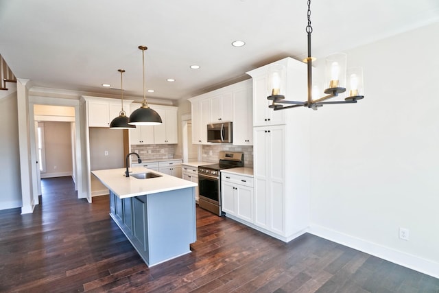 kitchen featuring white cabinetry, sink, hanging light fixtures, and stainless steel appliances