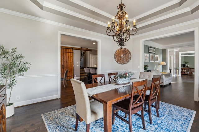 dining space with dark wood-type flooring, a tray ceiling, crown molding, and a barn door