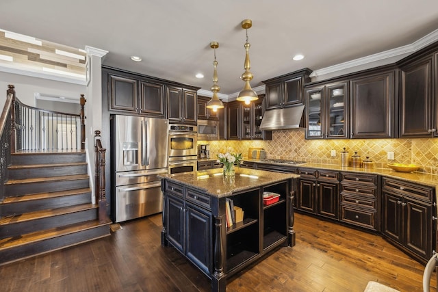 kitchen featuring stainless steel appliances, dark brown cabinets, dark stone counters, hanging light fixtures, and a center island