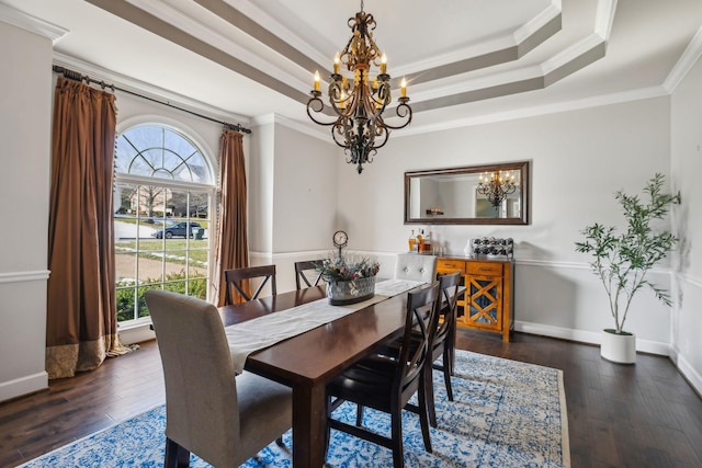 dining space featuring a raised ceiling, dark hardwood / wood-style floors, a wealth of natural light, and crown molding