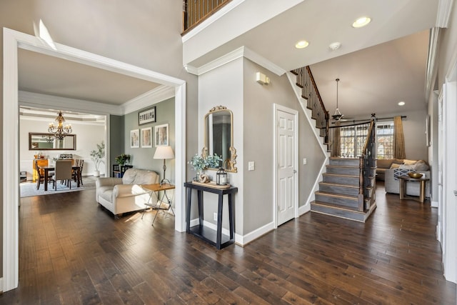 foyer entrance featuring dark hardwood / wood-style floors, a chandelier, and ornamental molding