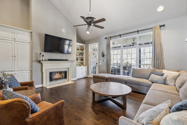 living room with ceiling fan, dark hardwood / wood-style flooring, high vaulted ceiling, and a fireplace